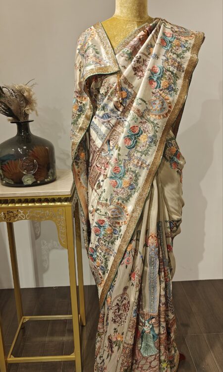 NrityaVilaas – Iktara’s Regal Rhythm in Threads

A regal creation from the Iktara line, this saree blends soft elegance with detailed hand embroidery depicting dancing beauties and floral artistry on a classic base.