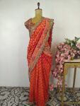 Red-orange pre drape saree with stitched blouse